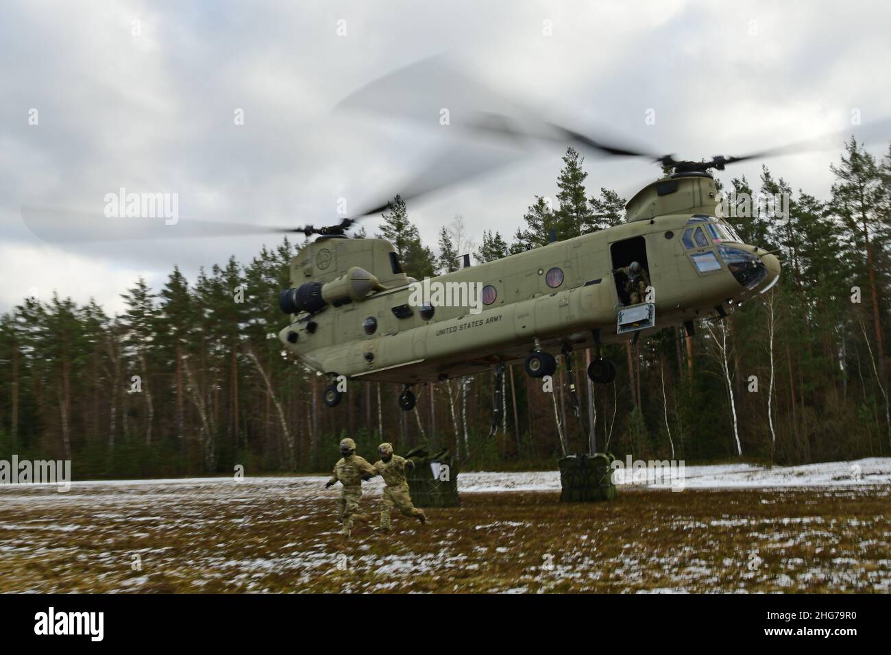 US-Soldaten, die der Comanche-Truppe, 1st Squadron, 2D Cavalry Regiment, zugewiesen sind, führen während einer situativen Trainingsübung (STX) auf Kaderebene im Trainingsgebiet Grafenwoehr, Deutschland, am 11. Januar 2022 Schlingentraglasoperationen mit einem CH-47 Chinook durch. (USA Armeefoto von Kevin Sterling Payne) Stockfoto