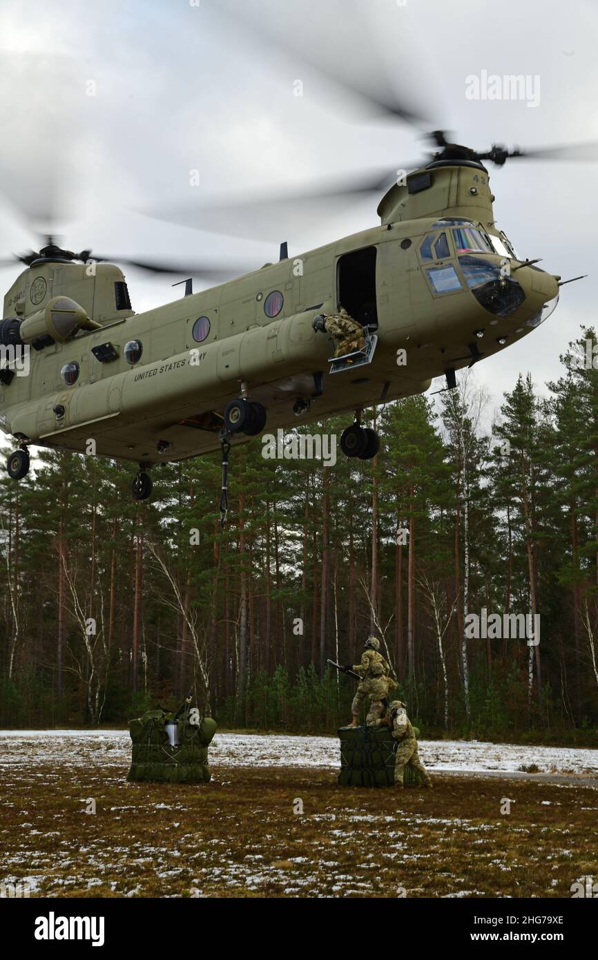 US-Soldaten, die der Comanche-Truppe, 1st Squadron, 2D Cavalry Regiment, zugewiesen sind, führen während einer situativen Trainingsübung (STX) auf Kaderebene im Trainingsgebiet Grafenwoehr, Deutschland, am 11. Januar 2022 Schlingentraglasoperationen mit einem CH-47 Chinook durch. (USA Armeefoto von Kevin Sterling Payne) Stockfoto