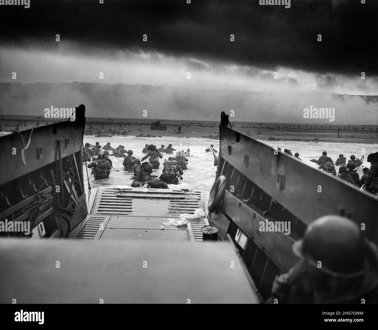 Die D-Day Landungen - ein Blick aus dem Inneren eines Landungsschiffes, das Männer des Infanterie-Regiments 16th, US 1st Infantry Division, zeigt, die am Omaha Beach mit dem rauchbedeckten Strand dahinter an Land wateten Stockfoto