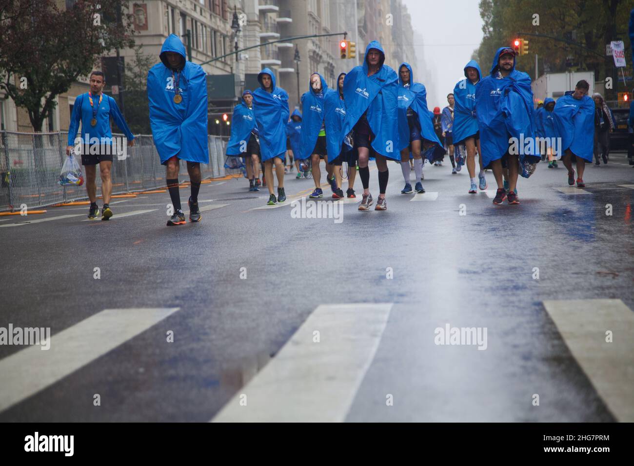 Männliche Marathonfahrer in Blue Capes Walking Down the Street, NYC, NY, USA Stockfoto