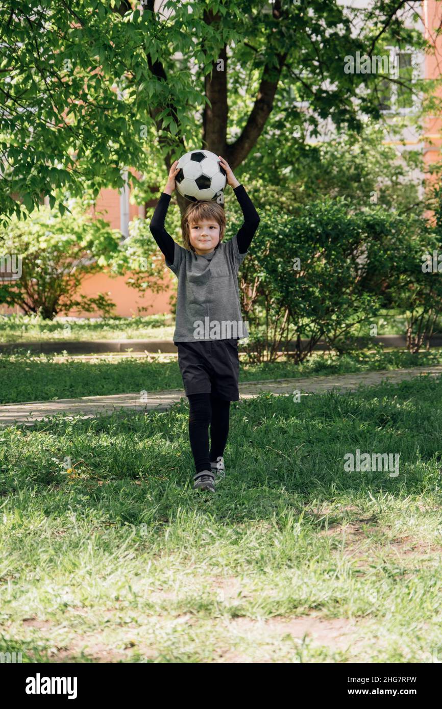 Kind spielt Fußball im Hof Stockfoto