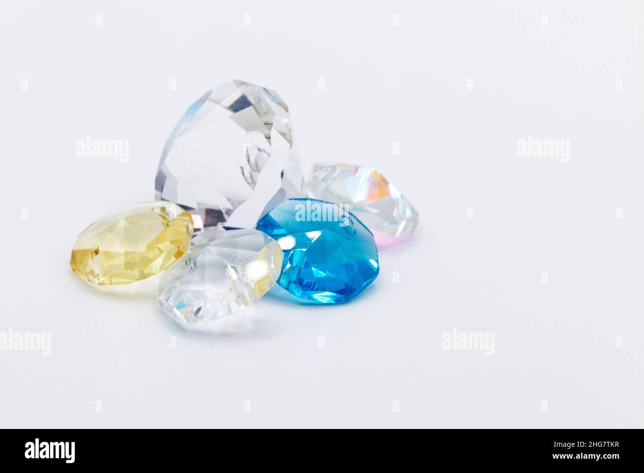 Kunststoff-Edelsteine in verschiedenen Farben auf weißem Hintergrund Stockfoto