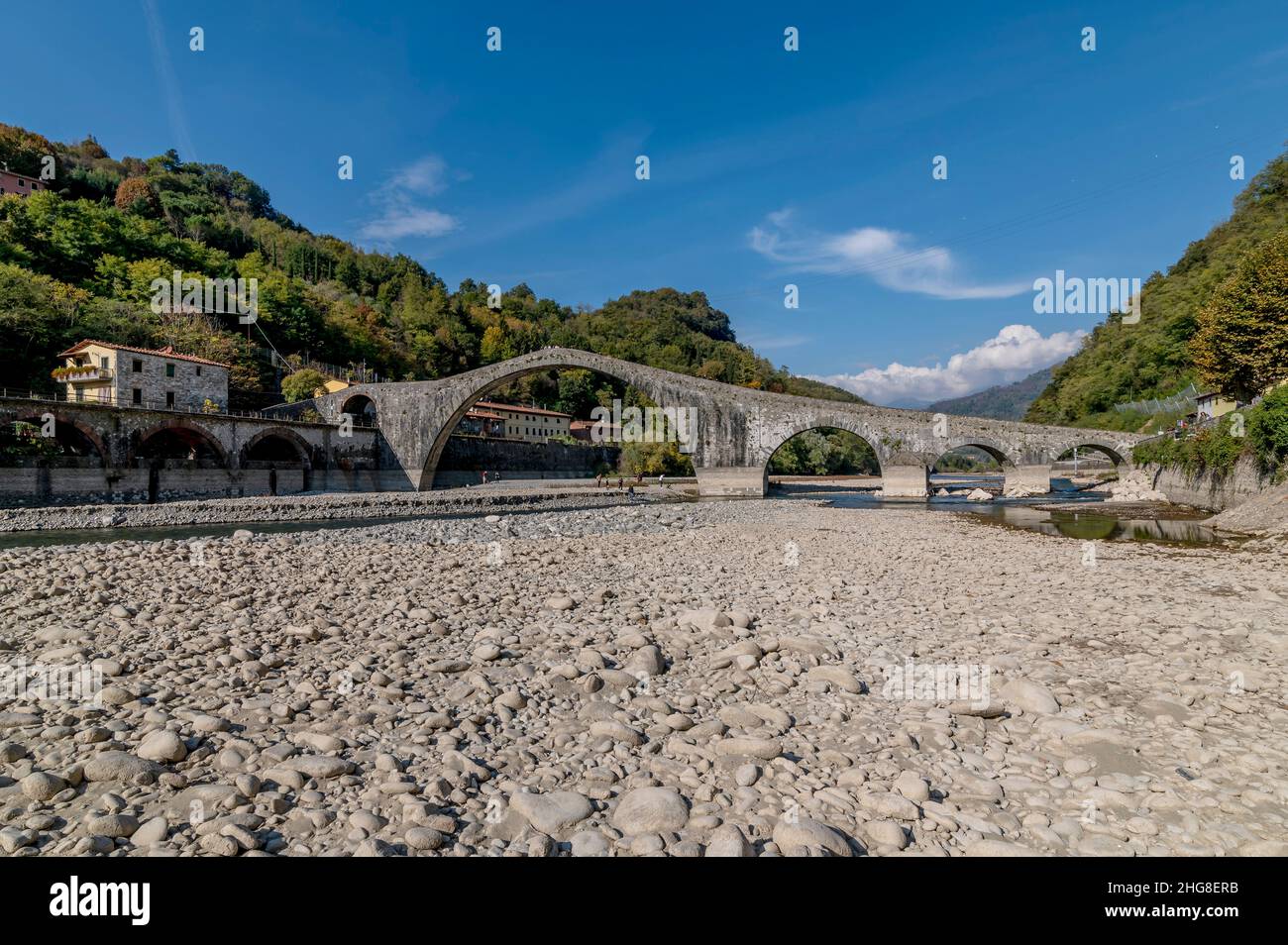 Eine große Menge von Steinen auf dem Bett des Flusses Serchio, fast trocken in der Nähe der alten Ponte della Maddalena, Lucca, Italien Stockfoto