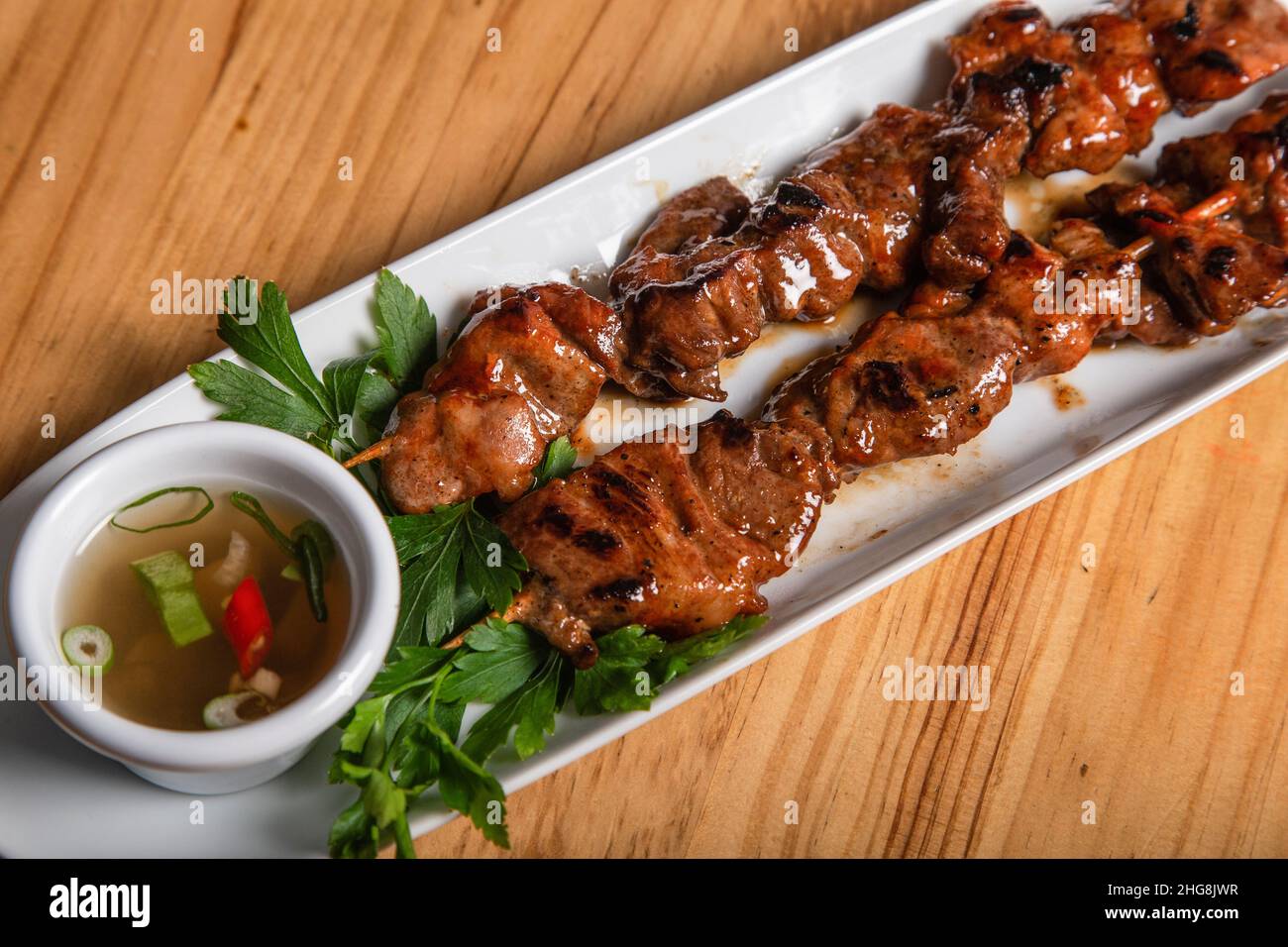 Gegrillte Fleischspieße, serviert mit gewürztem Essig. Philippinisches Essen. Stockfoto