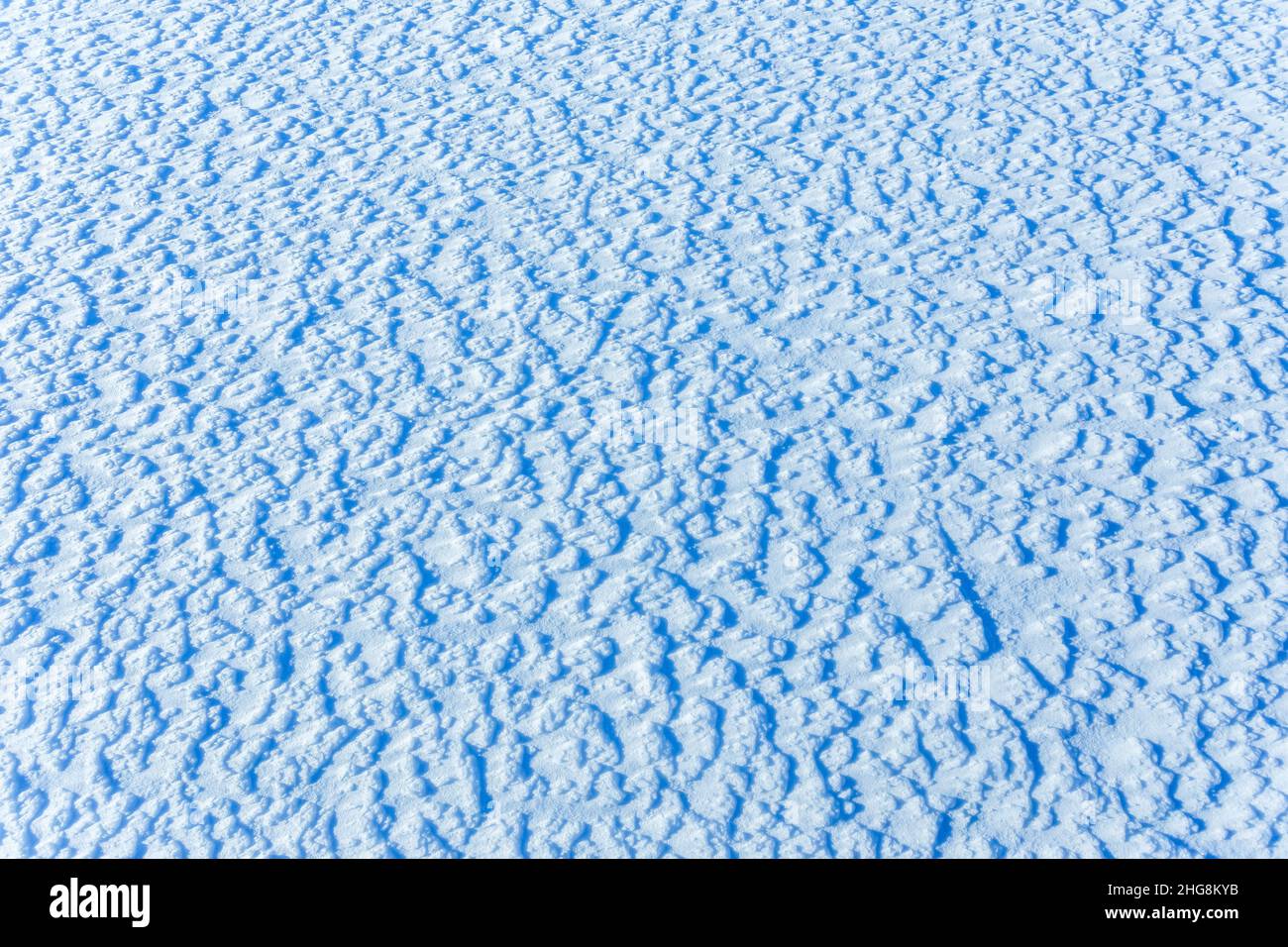 Textur des Schnees, weiß blaues Muster des Schnees, kalter Tag, natürliches Wintermuster nach dem Schneesturm Stockfoto