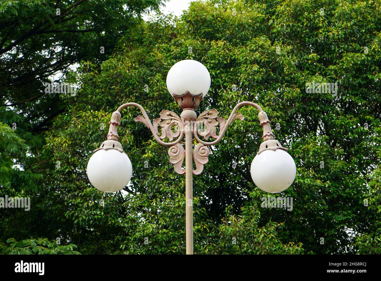 Runde Lampe am Mast, Außenbeleuchtung am klaren blauen Himmel. Fotos von weißen Laternen, die auf der Straße vor der Residenz aufgenommen wurden. Stockfoto