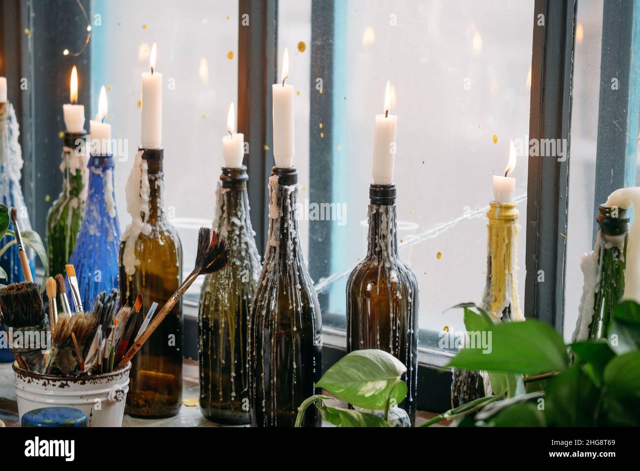 Kerzen in bunten Flaschen. Geschmolzenes Wachs, am Fenster. Natürliches  Licht, kreative Atmosphäre Vintage-Look auf Fensterbank Stockfotografie -  Alamy