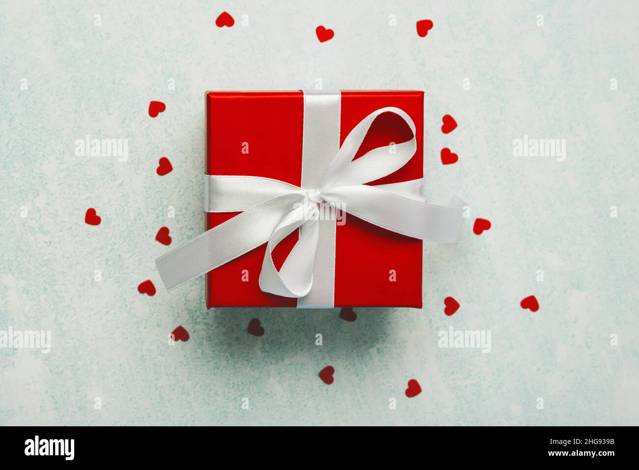 Draufsicht auf Valentinstag Geschenkbox und Herzen auf blauem Hintergrund. Konzept für die Valentinstag-Feier Stockfoto