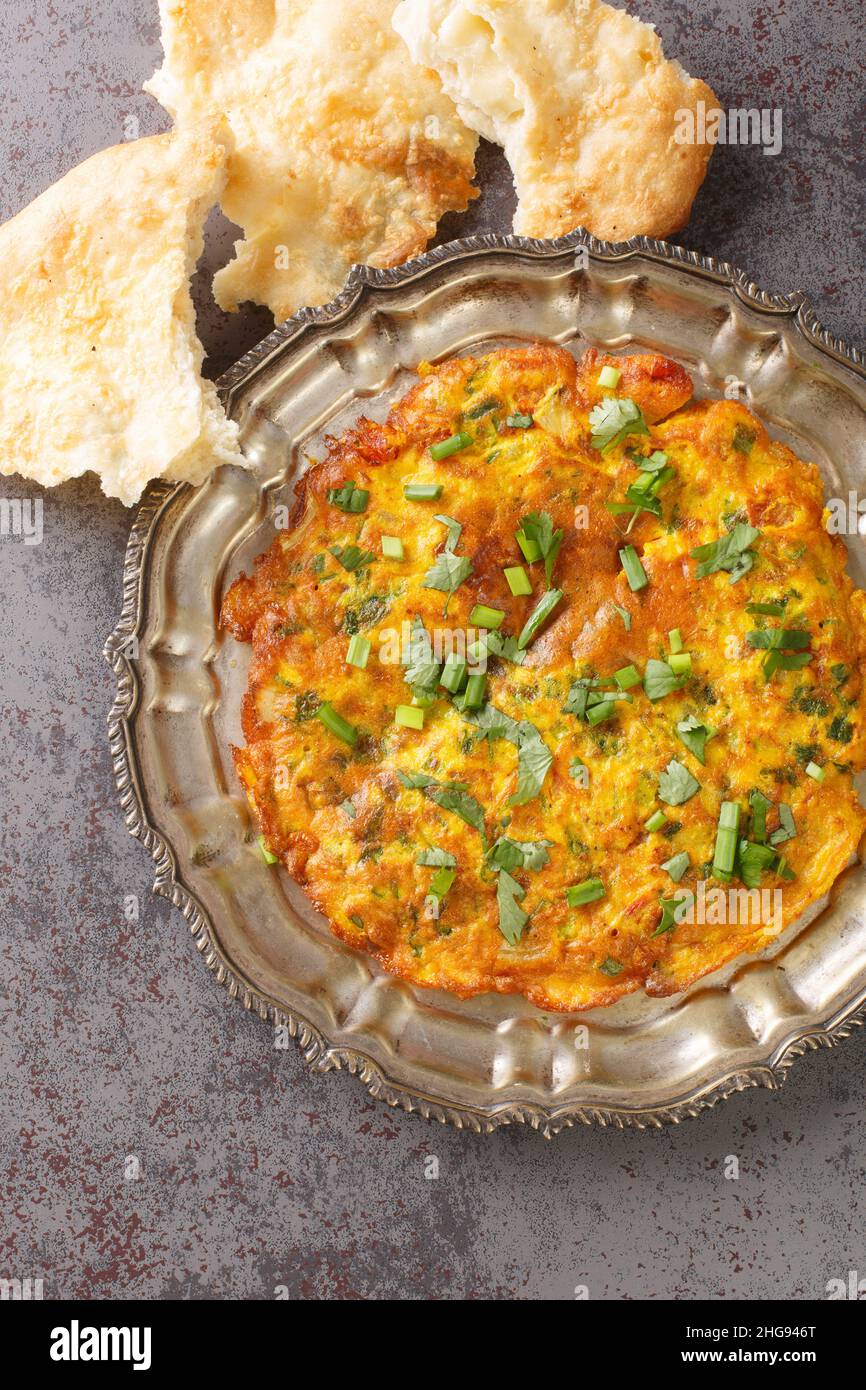 Masala Omelet Indian Style berühmte Street Food von Mumbai Nahaufnahme in der Platte auf dem Tisch. Vertikale Draufsicht von oben Stockfoto