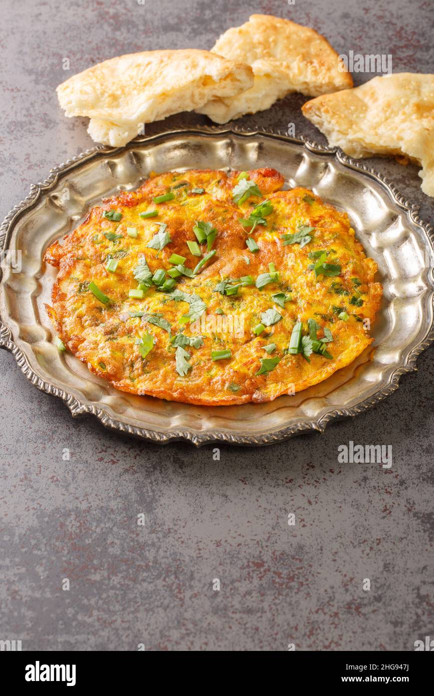 Indische Rezepte Masala Omelet mit frischem Gemüse in der Nähe auf dem Teller auf dem Tisch. Vertikal Stockfoto