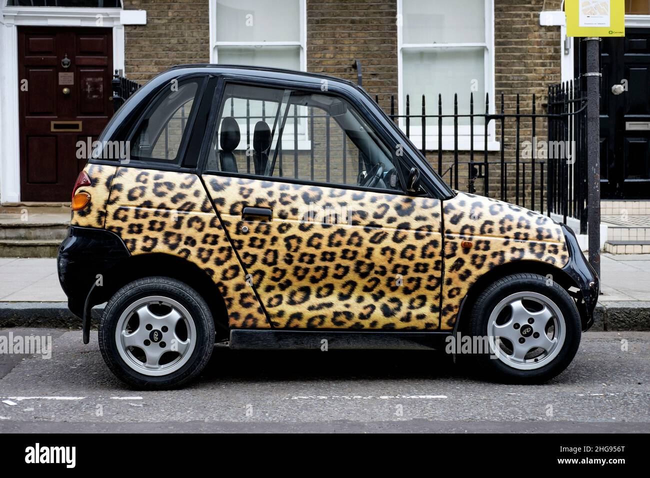 Ein Reva G-Wiz Elektroauto mit Leopardendruck-Design-Verkleidung, geparkt auf der Straße, London, Großbritannien Stockfoto