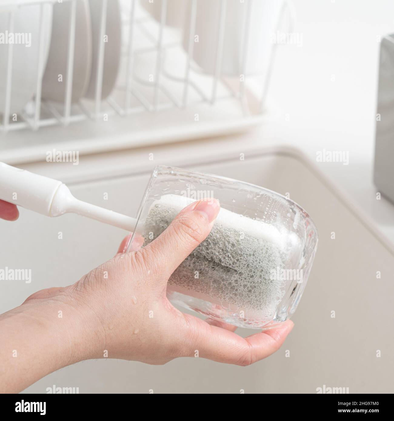 Nahaufnahme der Frau Hausfrau macht das Geschirr zu Hause Küche mit Waschschwamm und Spülen. Stockfoto