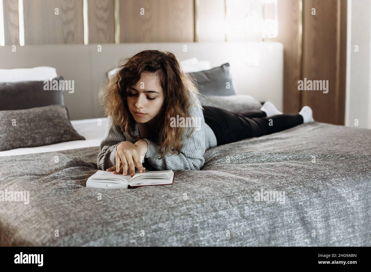 Teenager Mädchen liest Buch auf ihrem Bett Stockfoto