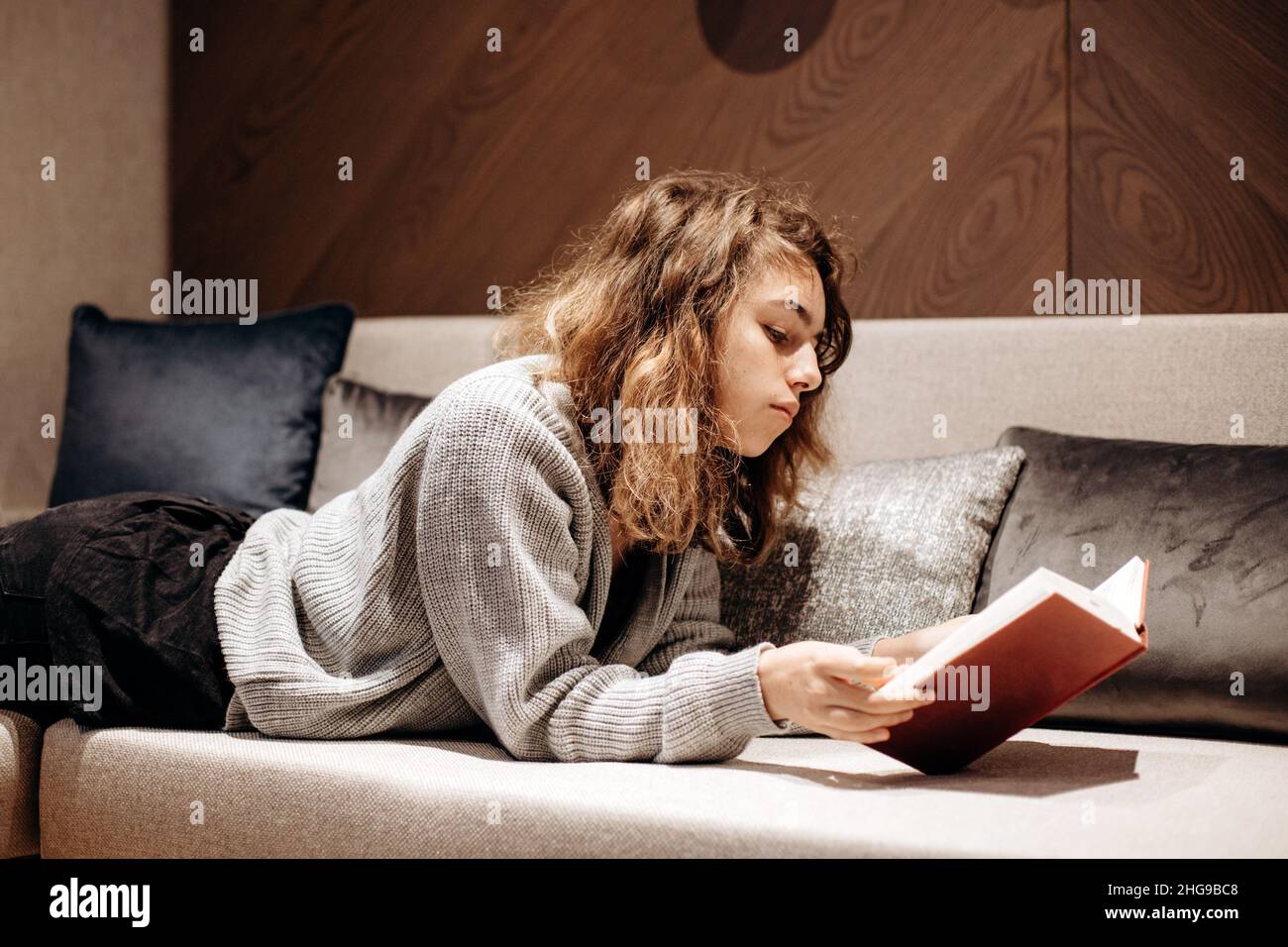 Teenager Mädchen Buch auf der Couch zu Hause lesen Stockfoto