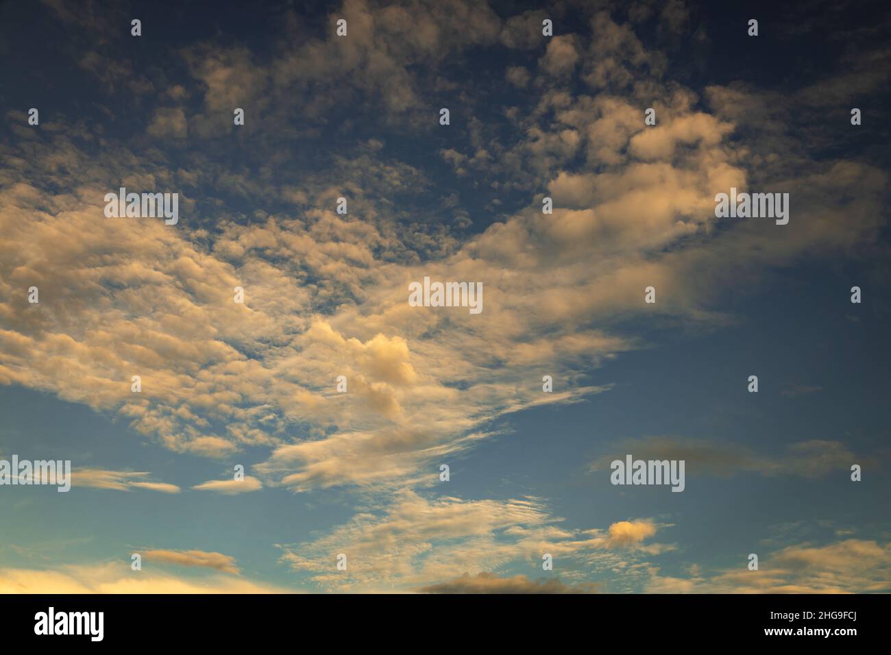 Schöne kleine vereinzelte Wolken am Himmel während des Sonnenuntergangs. Ressource für Designer für Ersatzdecken. Stockfoto
