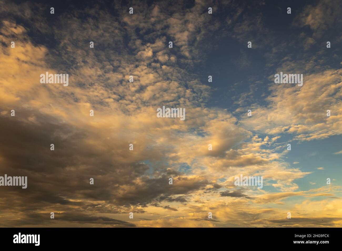 Schöne kleine vereinzelte Wolken am Himmel während des Sonnenuntergangs. Ressource für Designer für Ersatzdecken. Stockfoto