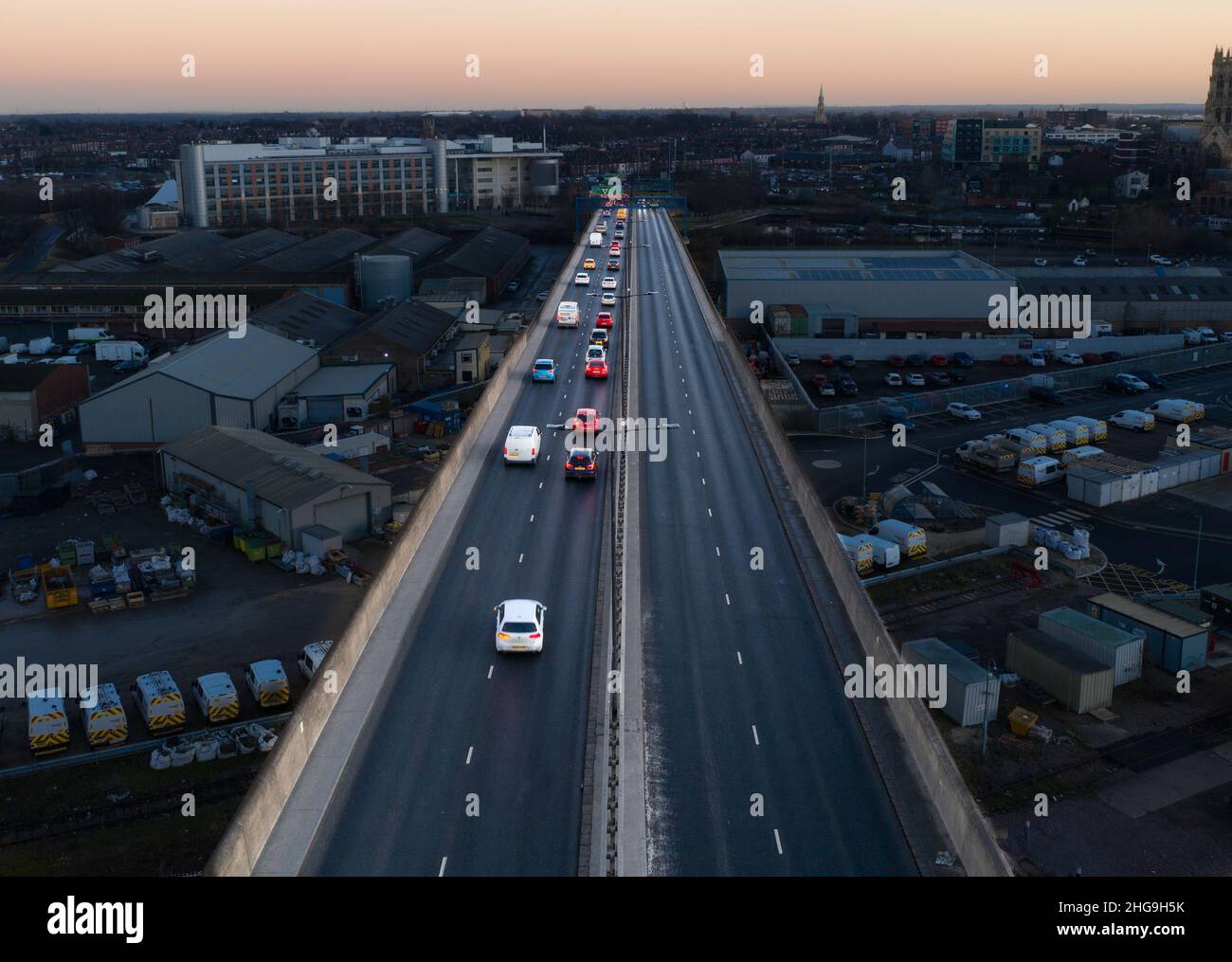Luftaufnahme des Verkehrs, der nachts während der abendlichen Hauptverkehrszeit eine Stadt auf einer Autobahnüberführung verlässt Stockfoto