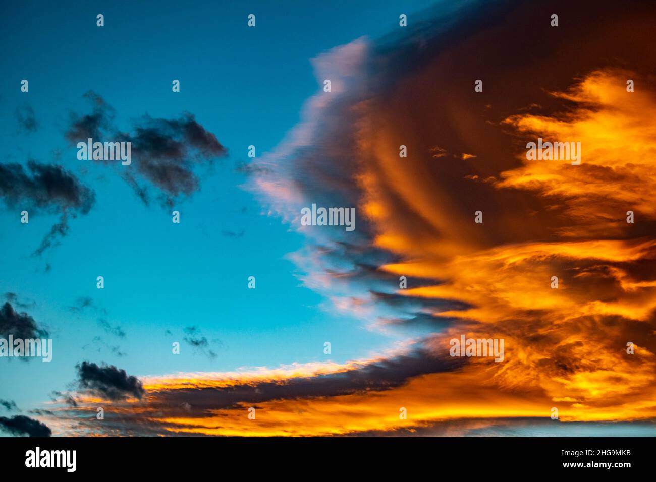 Goldene orange Wolken vor blauem Himmel über dem Mittelmeer während Sonnenuntergang Tapete Hintergrund Stockfoto
