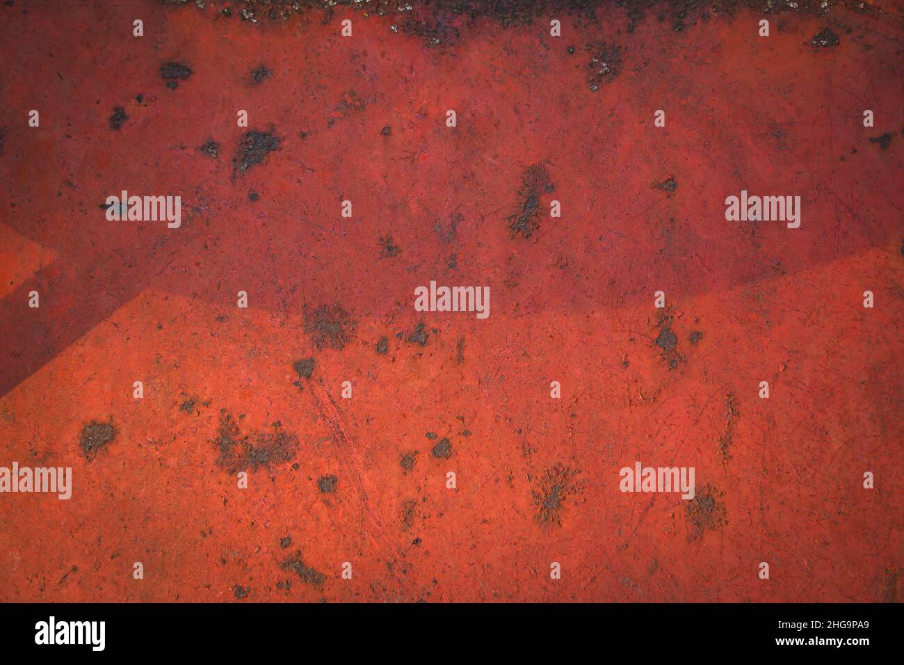 Rostige Metalloberfläche mit roter Farbe mit Flecken bedeckt. Abgenutzter Hintergrund mit rostiger Metallstruktur. Stockfoto