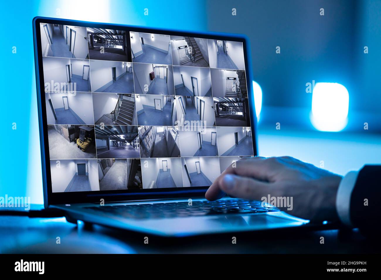 Der Bediener des Sicherheitssystems sieht sich CCTV-Aufnahmen am Schreibtisch an Büro Stockfoto