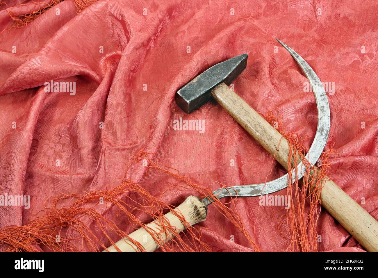 Hammer und Sichel auf den roten Stoff. Symbol der kommunistischen Bewegung Stockfoto