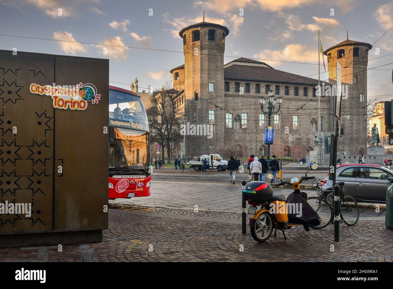 Ein Touristenbus mit Stadtbesichtigung auf dem Piazza Castello Platz vor dem Casaforte von Acaja im Zentrum von Turin bei Sonnenuntergang, Piemont, Italien Stockfoto
