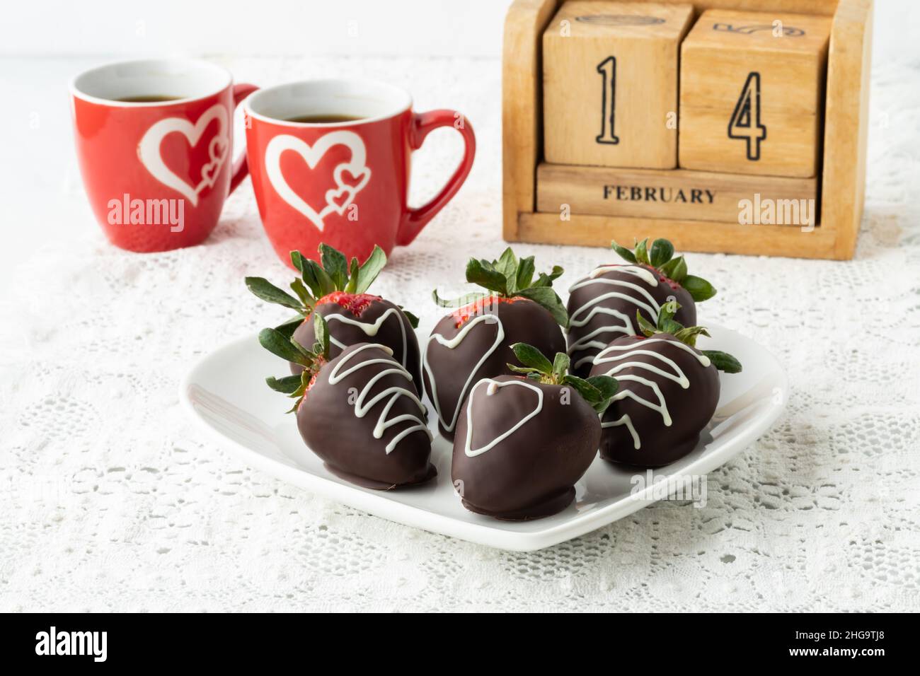 Wir feiern den Valentinstag mit Erdbeeren mit Schokoladenüberzug und Kaffee. Stockfoto