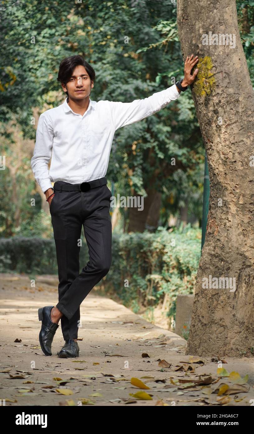 Porträt eines glücklichen lächelnden jungen Geschäftsmannes, der im Park läuft Stockfoto