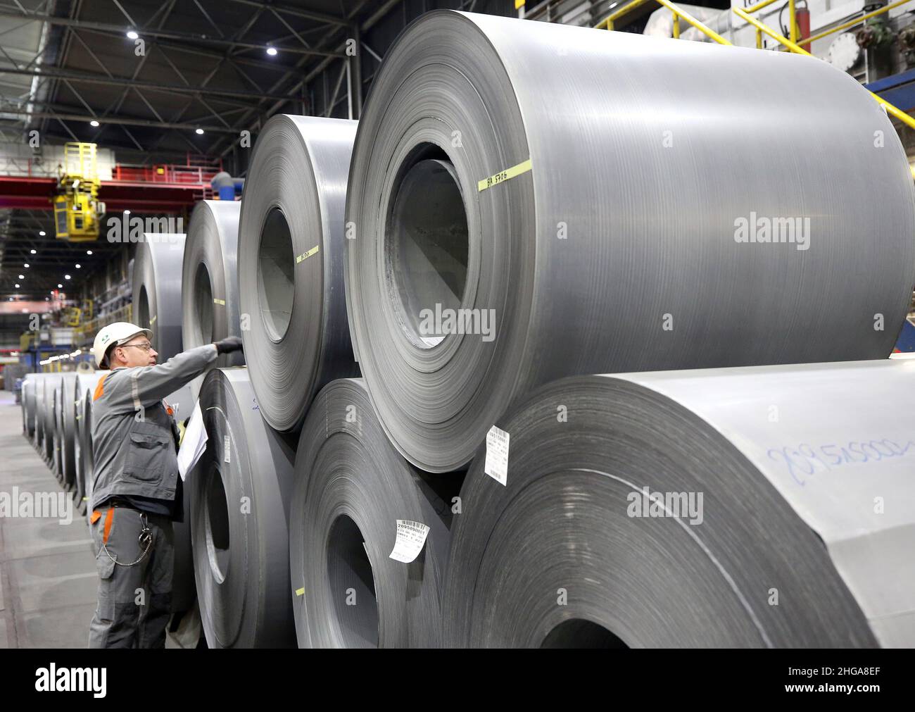 Gelsenkirchen, Deutschland. 19th Januar 2022. Ein thyssenkrupp-Mitarbeiter markiert Coils aus CO2-reduziertem Spezialstahl mit einem Zettel Papier. Deutschlands größter Stahlproduzent verkauft nun auch Spezialplatten für die Energiewirtschaft, deren Produktion insgesamt rund 50 Prozent weniger Kohlendioxid produziert als herkömmliche Produktion. Quelle: Roland Weihrauch/dpa/Alamy Live News Stockfoto