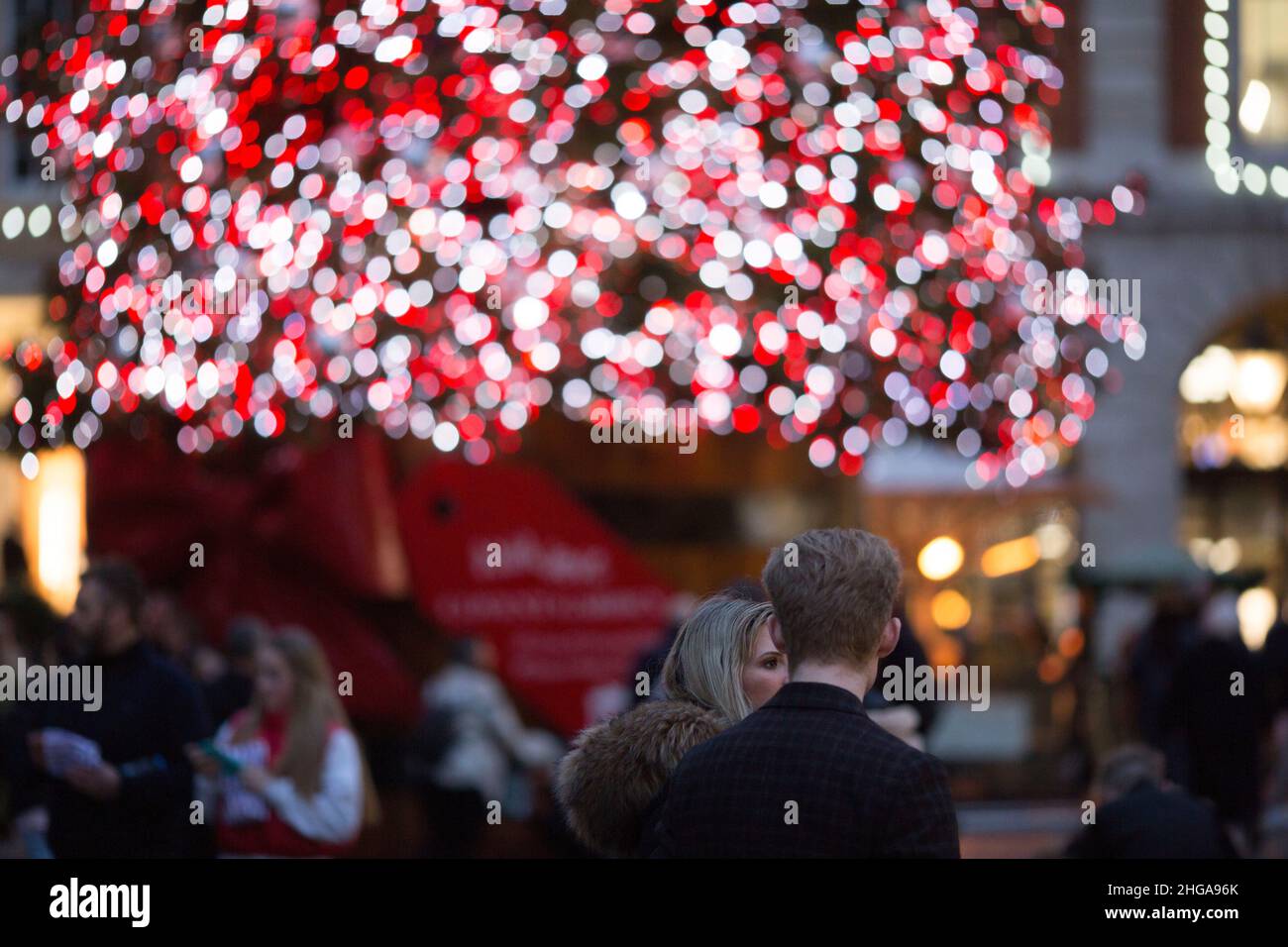 Am Abend des Nachrichtenjahres blicken die Menschen in Covent Garden, im Zentrum von London, vor festliche Lichter. Stockfoto