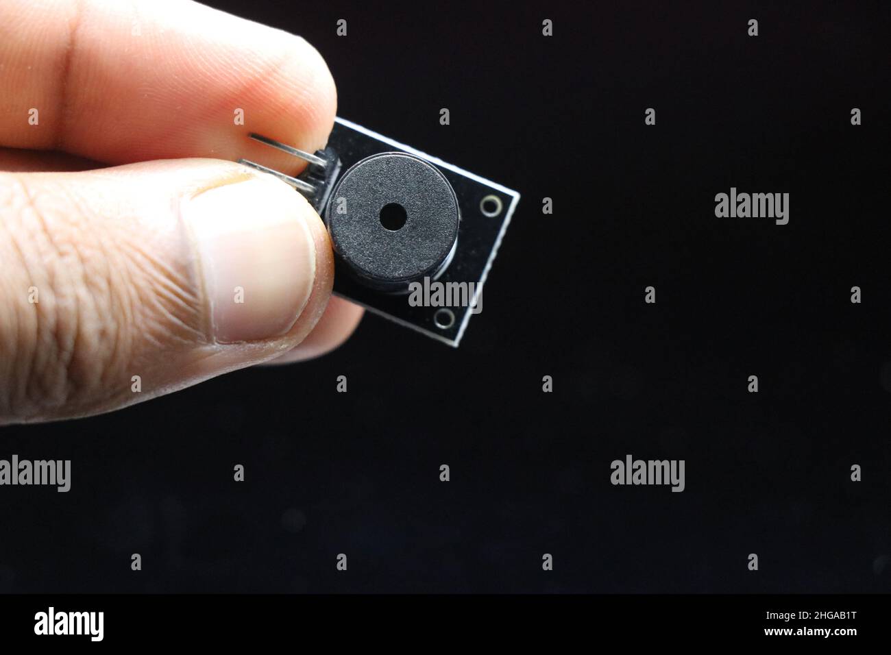 Passives Modul für Mikrocontroller und andere elektronische Projekte, isoliert auf schwarzem Hintergrund in der Hand gehalten Stockfoto