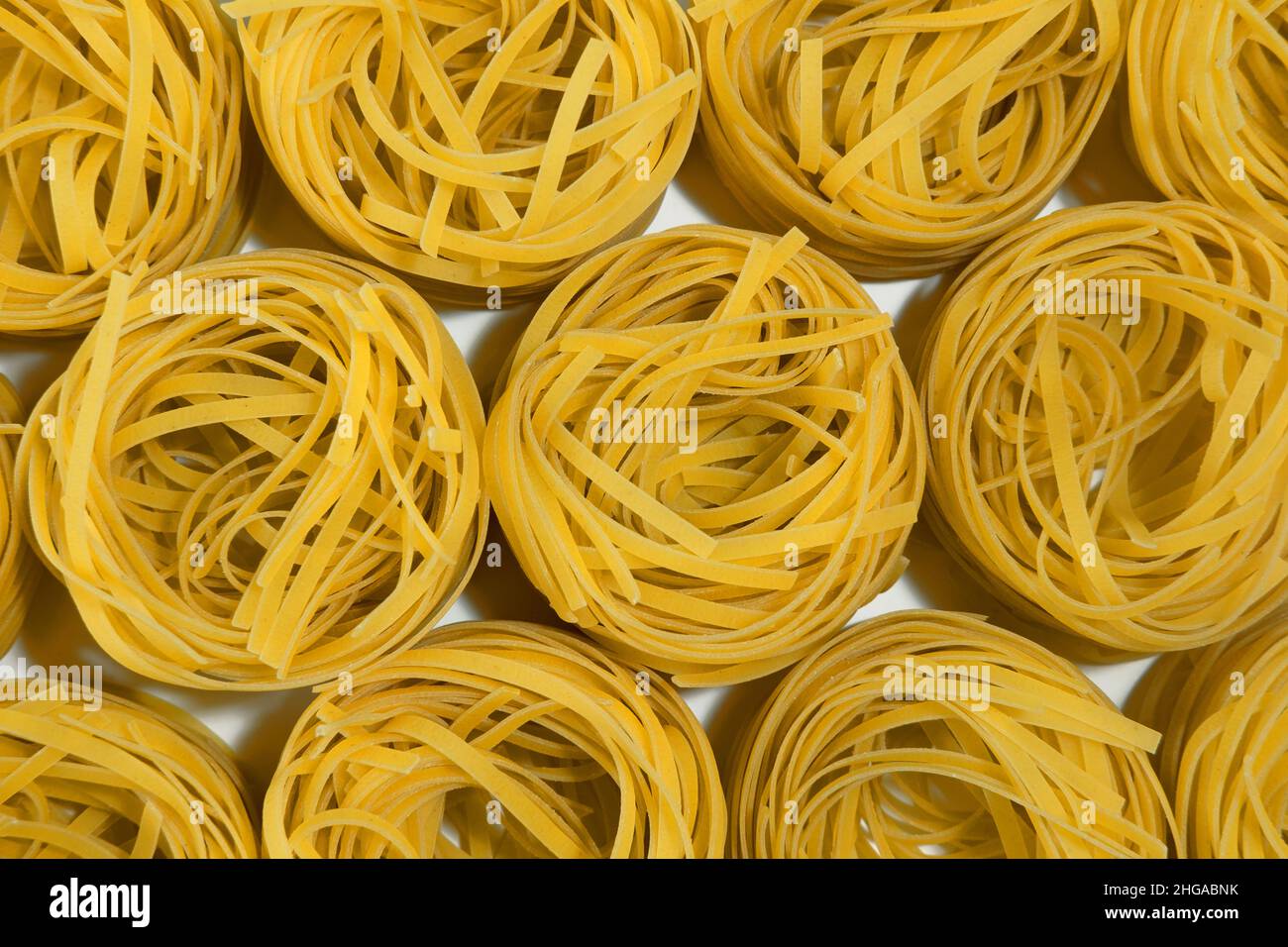 Italienische Pasta. Spaghetti Capellini isoliert auf weißem Hintergrund, Draufsicht. Pasta in Form von Nestern. Muster Stockfoto