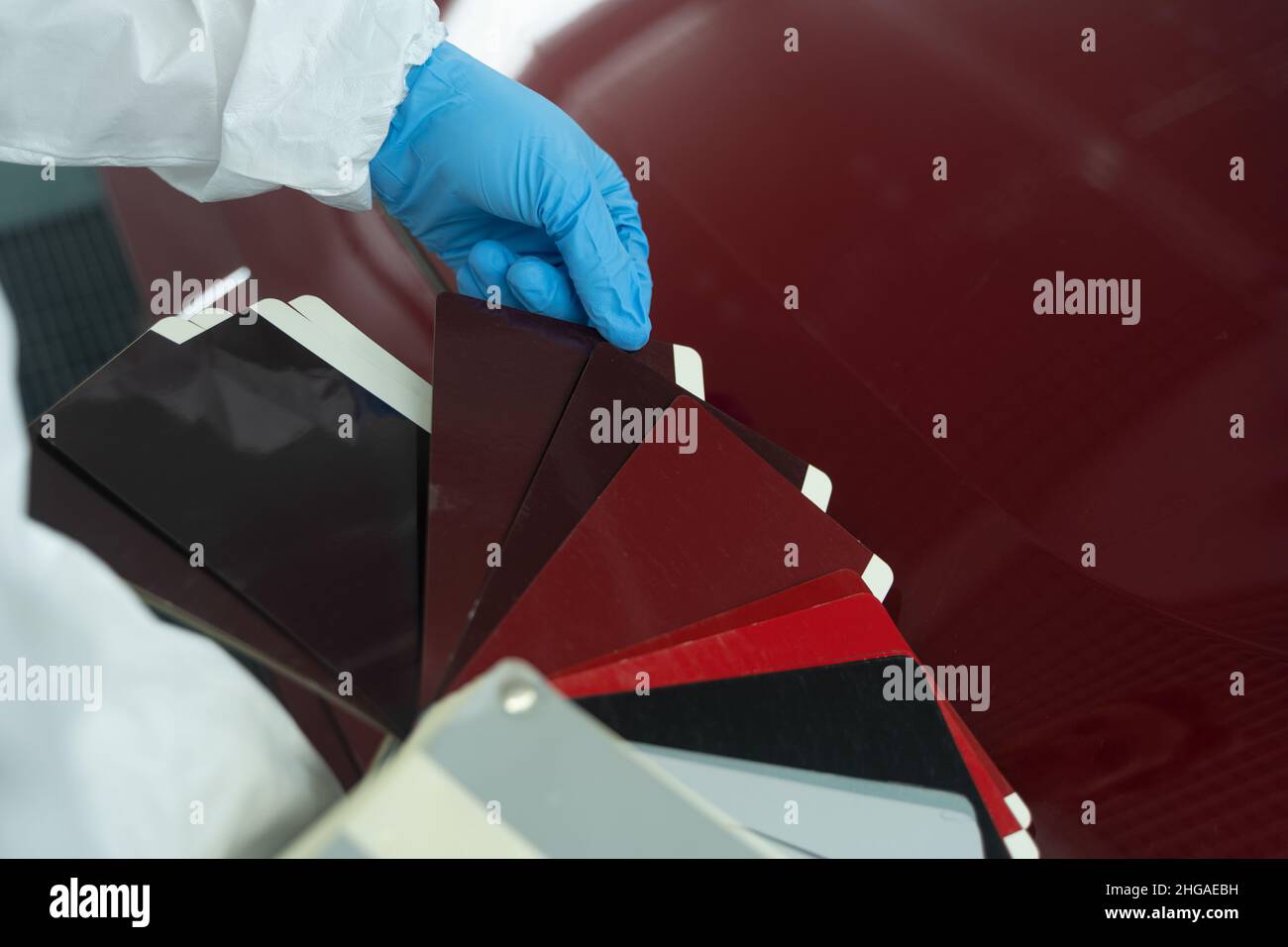 Vor dem Lackieren des Fahrzeugs wählt der Karosseriearbeiter die richtige Farbe aus Stockfoto