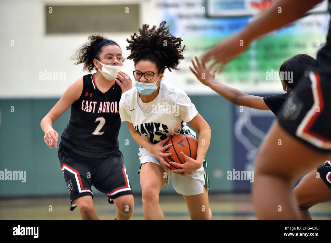 USA. Spieler, der versucht, die Kontrolle über den Basketball zu behalten, während er in die Farbe eintritt, nachdem er an einem Gegner vorbeiverhandelt hat. Stockfoto