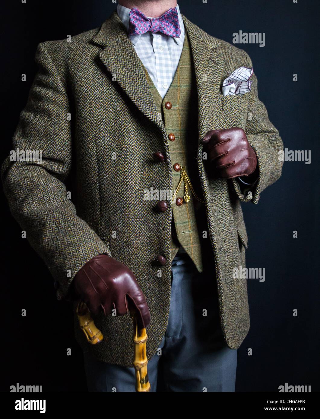 Porträt des Gentleman in Tweed-Anzug und Lederhandschuhe halten Regenschirm. Klassischer und exzentrischer englischer Gentleman. Stockfoto