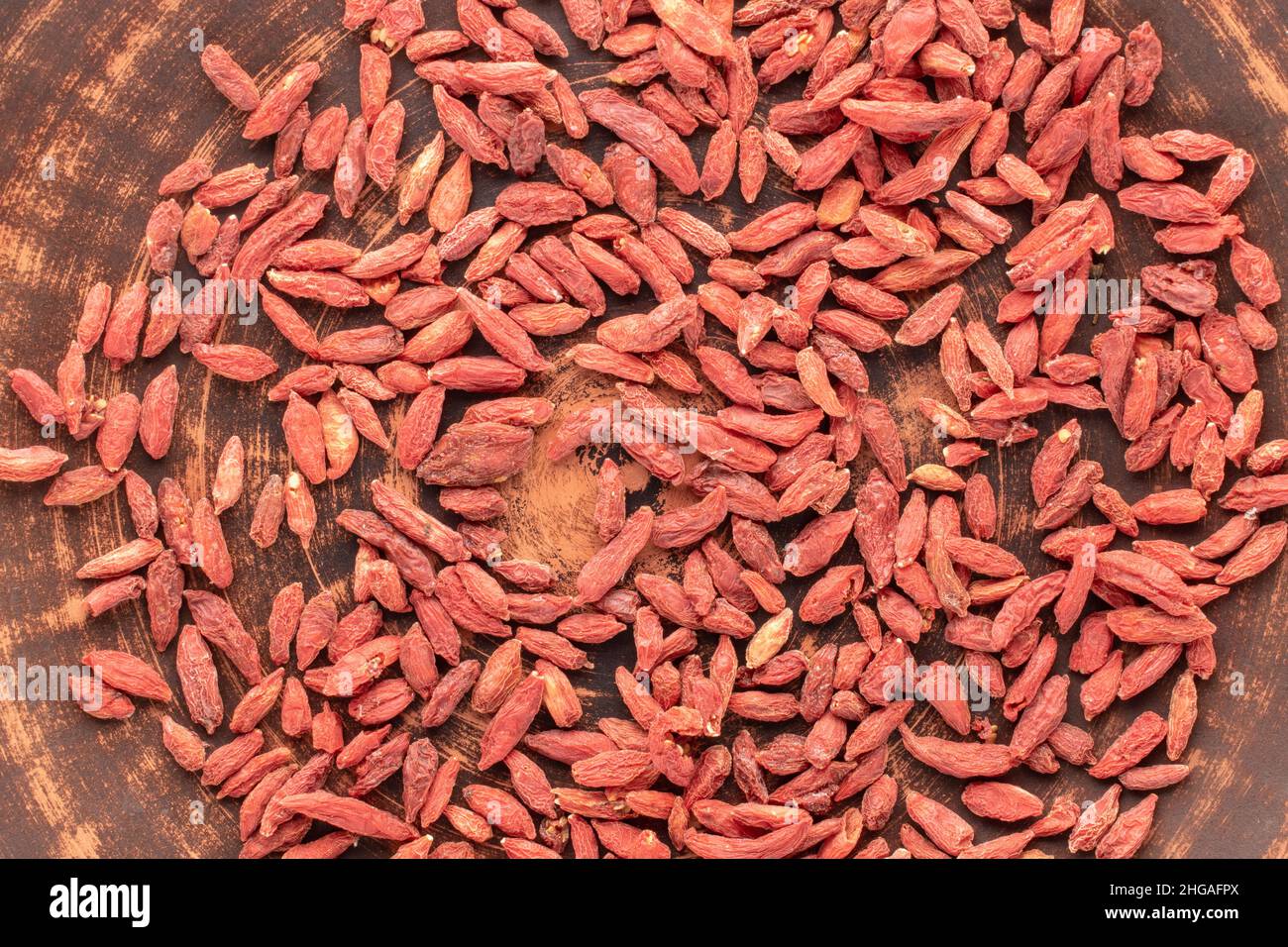 Getrocknete Bio-Goji-Beeren auf einer Tonschale, Makro, Draufsicht. Stockfoto