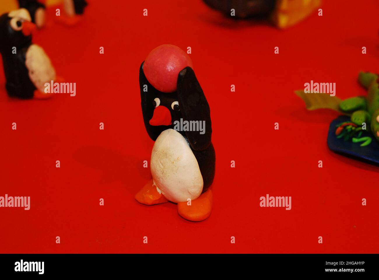 Eine Nahaufnahme eines Tonpinguins, basierend auf der animierten TV-Figur Pingu, die während eines pädagogischen Workshops zum Spielen und Basteln/Modellbau für Kinder gemacht wurde Stockfoto
