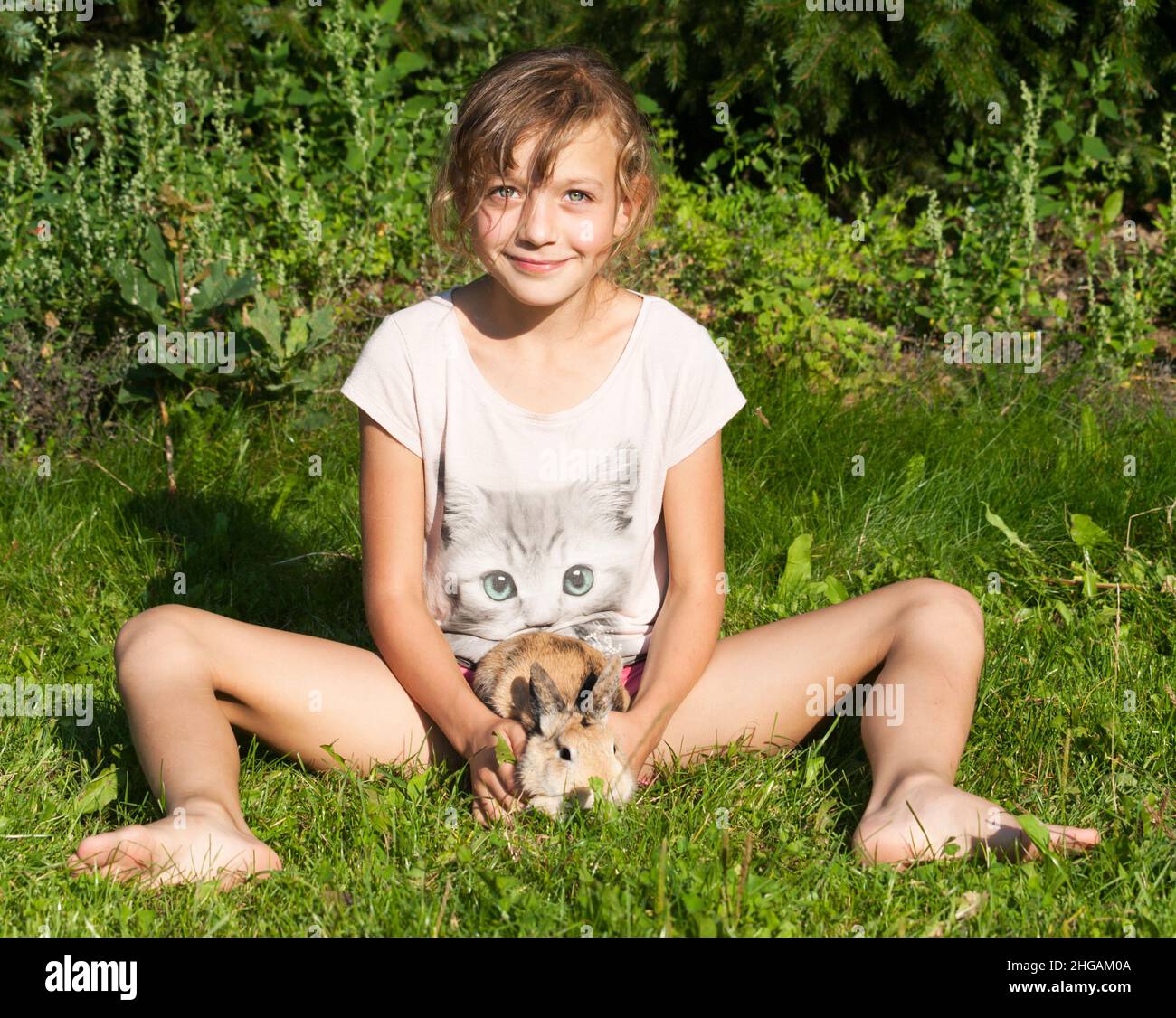 Mädchen spielen mit Haustier Kaninchen Stockfoto