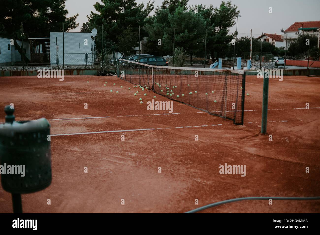 Ein großer Tennisplatz draußen, viele Bälle auf dem Boden. Sport, gesunder Lebensstil Stockfoto