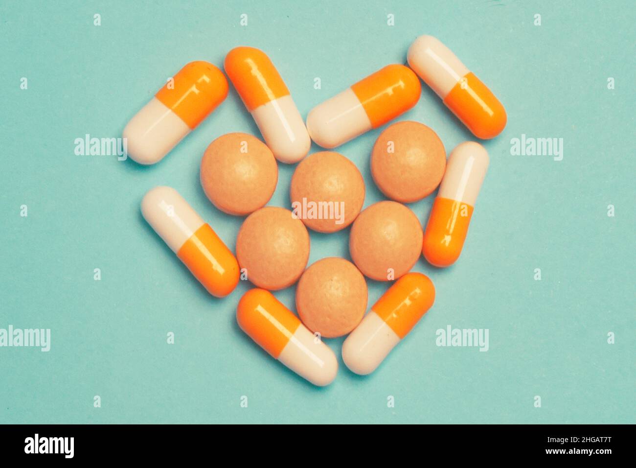 Pillen auf blauem Hintergrund. Verschiedene pharmazeutische Medikamente Pillen, Tabletten und Kapseln, Gesundheit Makro. Herztabletten. Herz aus bunten Pillen auf b Stockfoto