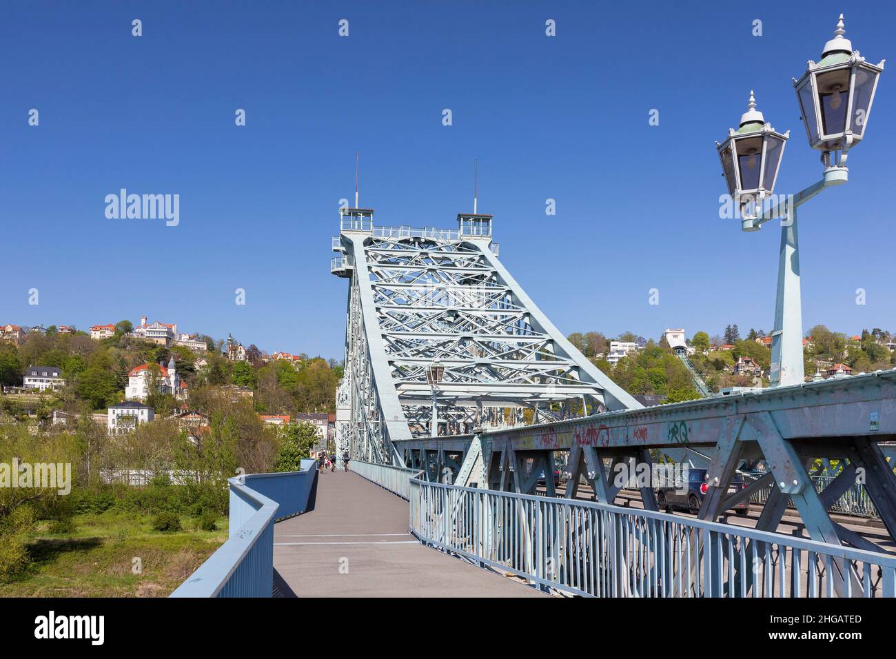 Auf der Brücke Blaues Wunder mit historischer Laterne- und Stahlkonstruktion, im Hintergrund der Elbhang von Loschwitz mit Aussichtsterstaurant Stockfoto