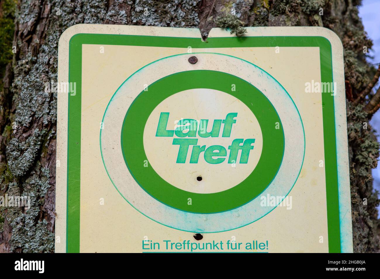 Schild mit dem deutschen Text 'Lauftreff' übersetzt in Englisch 'Treffpunkt für Läufer. Ein Treffpunkt für alle Stockfoto