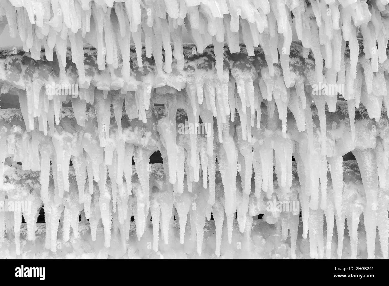 Eiszapfen hängen vom verschneiten Dach, Hintergrund Stockfoto