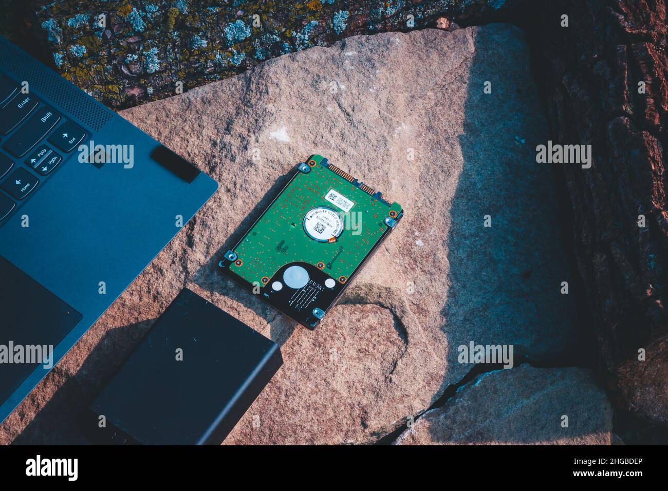 Laptop-ethernet-Kabel und Festplatte auf einem Felsen Stockfoto
