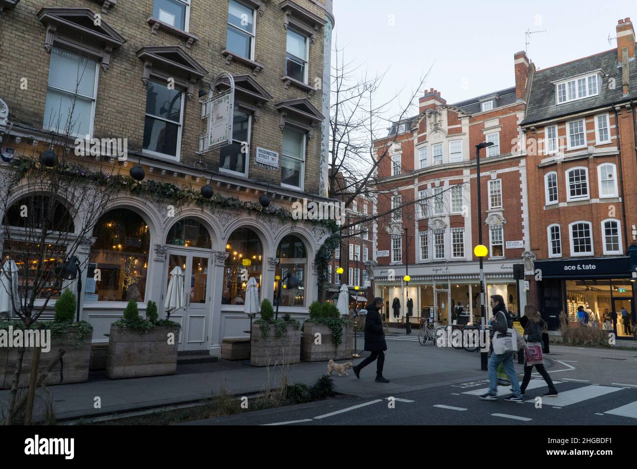 London, Großbritannien, 16. Januar 2022: Auf der Marylebone High Street im Zentrum Londons funkeln Lichter, wenn die Dämmerung herabbricht. Ein paar Leute besuchen Pubs und Cafés und dort Stockfoto