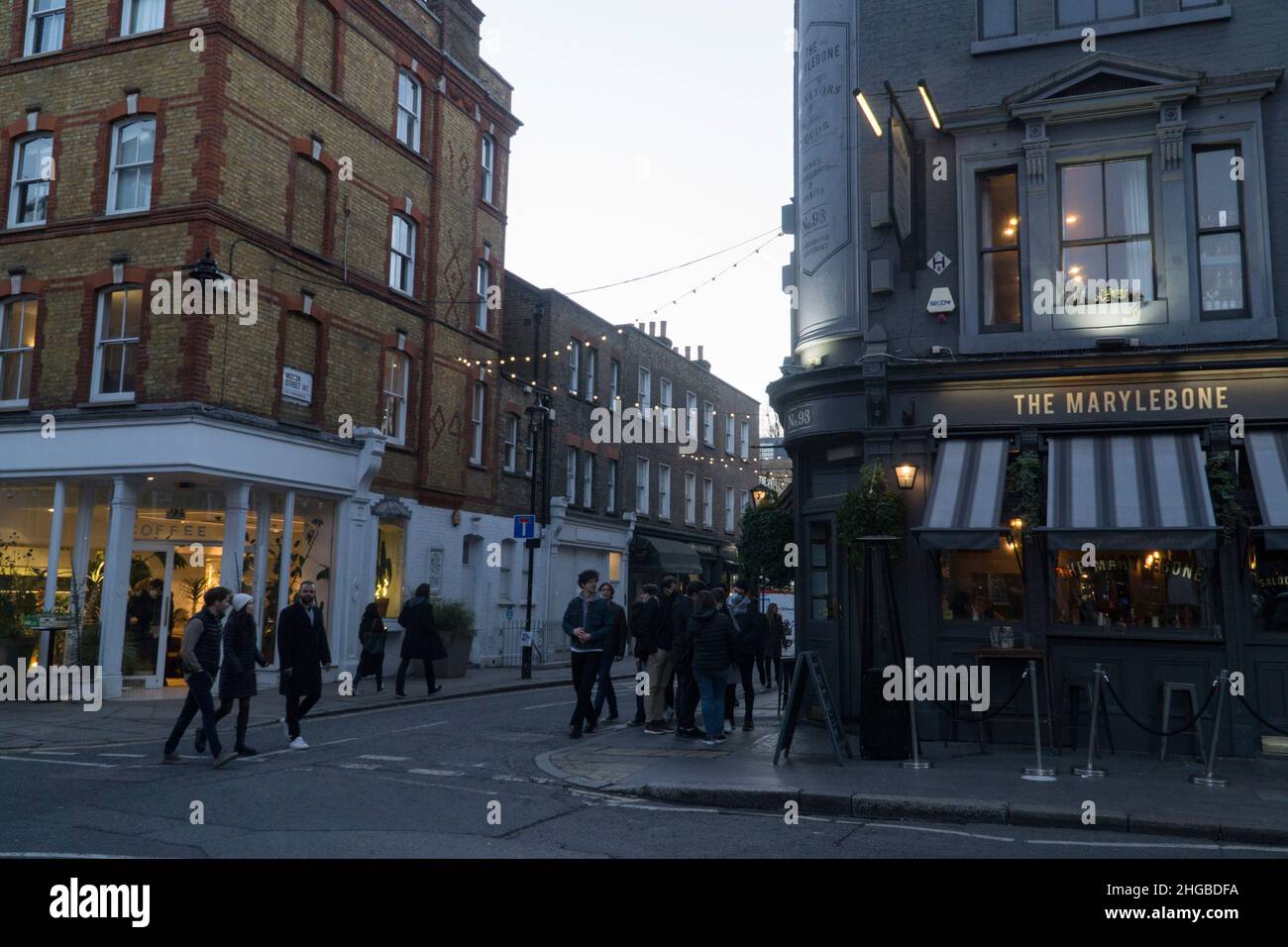 London, Großbritannien, 16. Januar 2022: Auf der Marylebone High Street im Zentrum Londons funkeln Lichter, wenn die Dämmerung herabbricht. Ein paar Leute besuchen Pubs und Cafés und dort Stockfoto