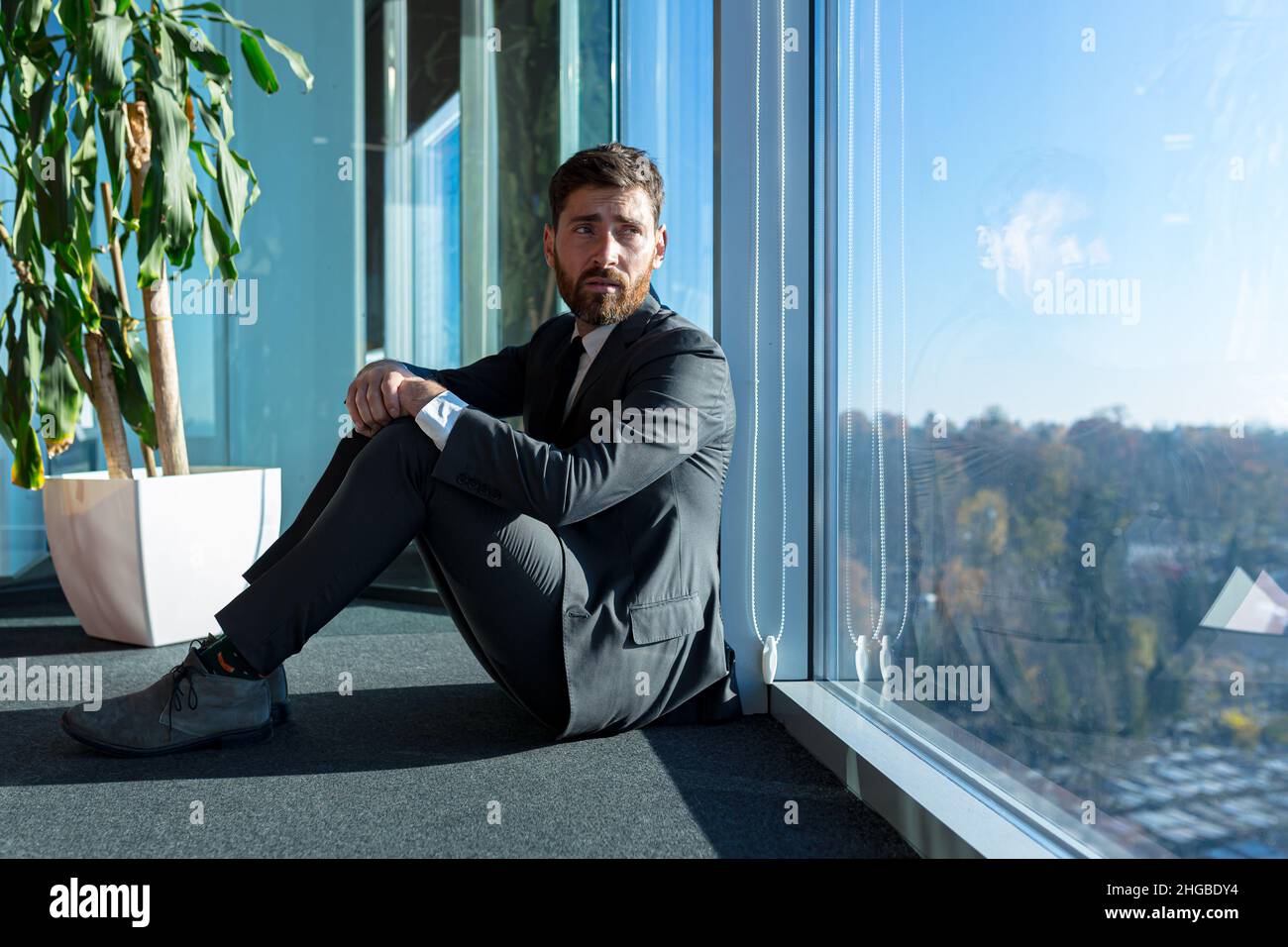 Deprimierter Mann, der auf der Büroetage saß, der Angestellte war enttäuscht und gefeuert Stockfoto