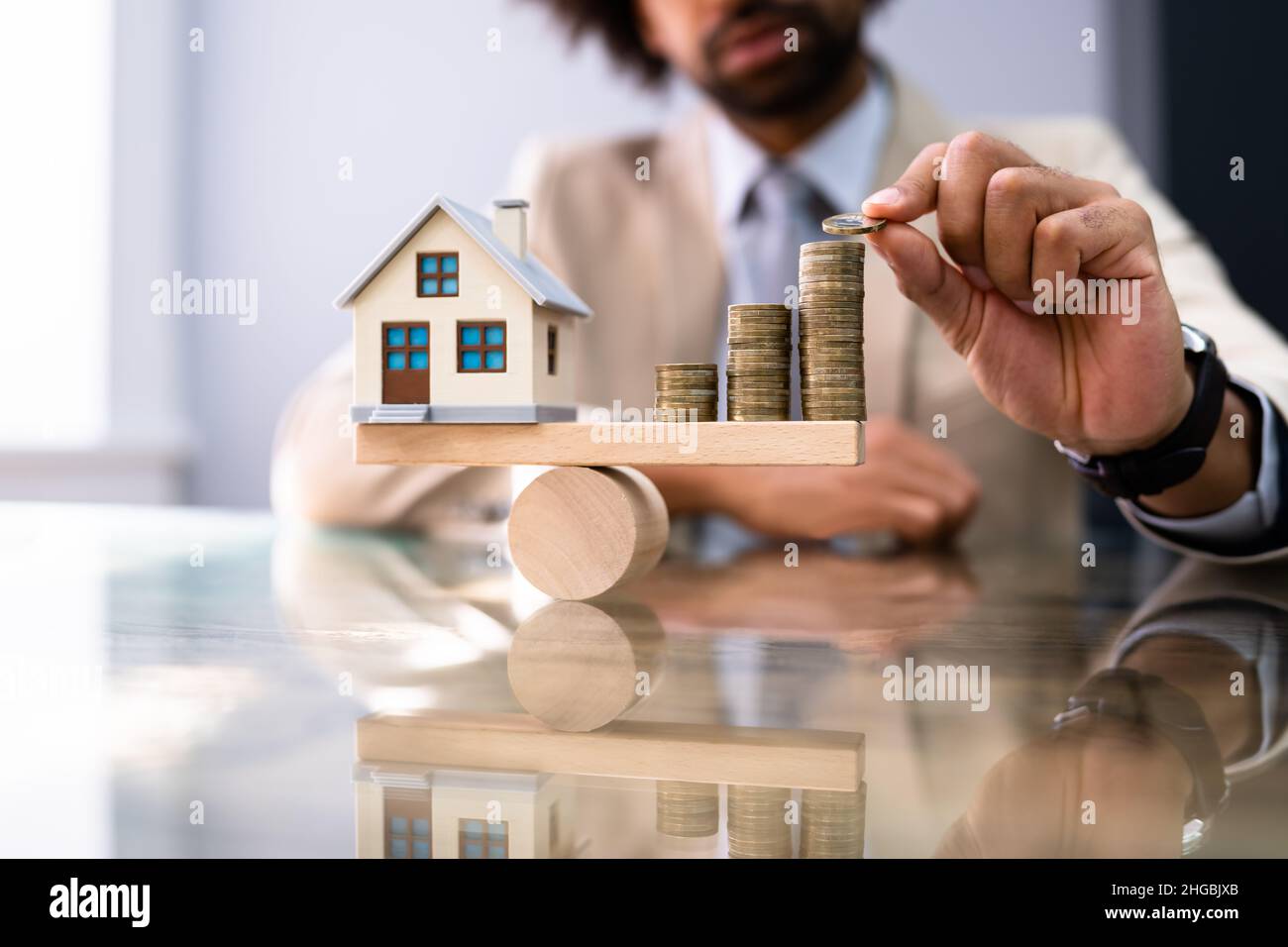 Haus Modell Balance Gleichgewicht Konzept. Immobiliengeld Stockfoto