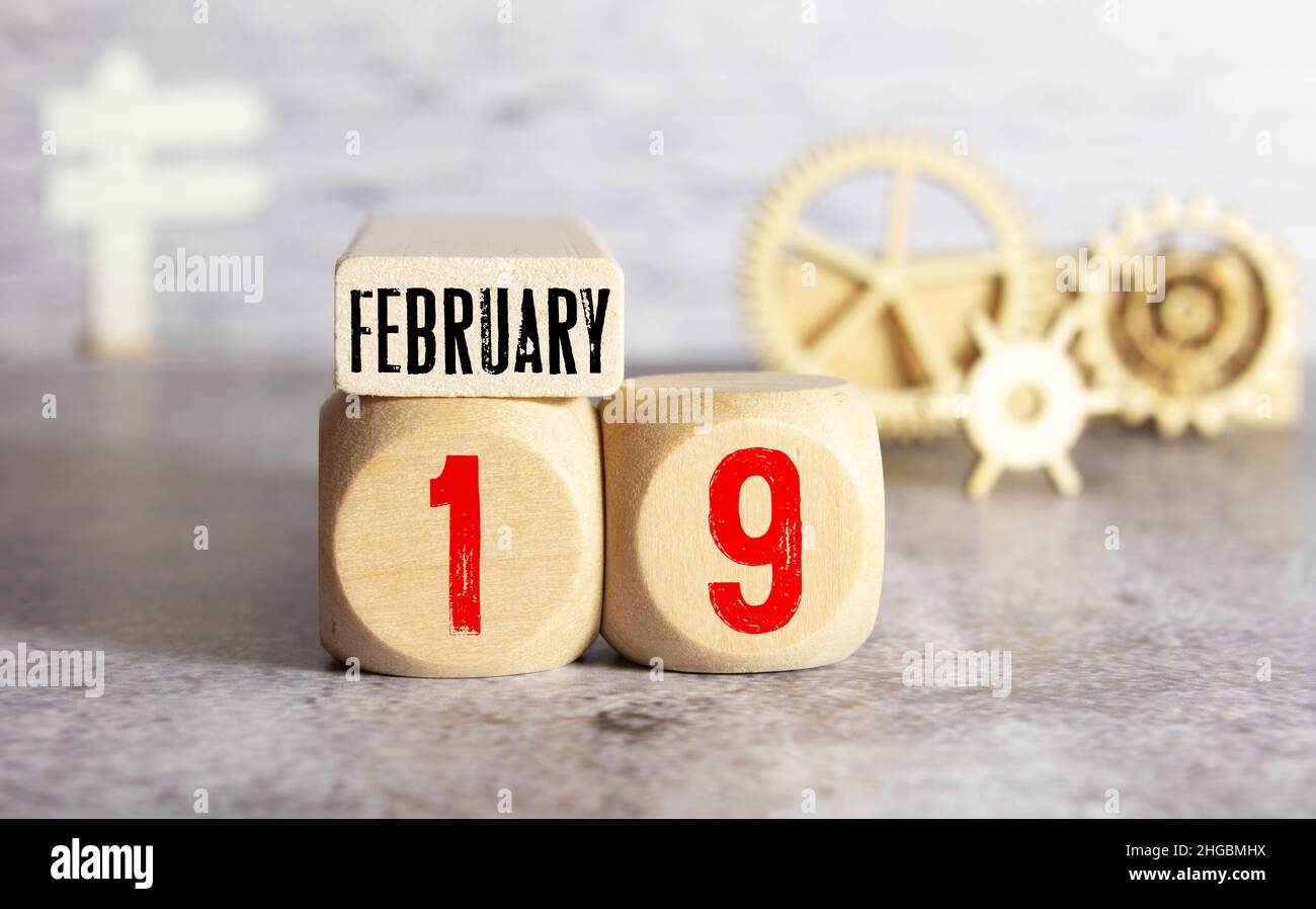 Würfelförmiger Kalender für Februar 19 auf Holzfläche mit Platz für Text. Stockfoto