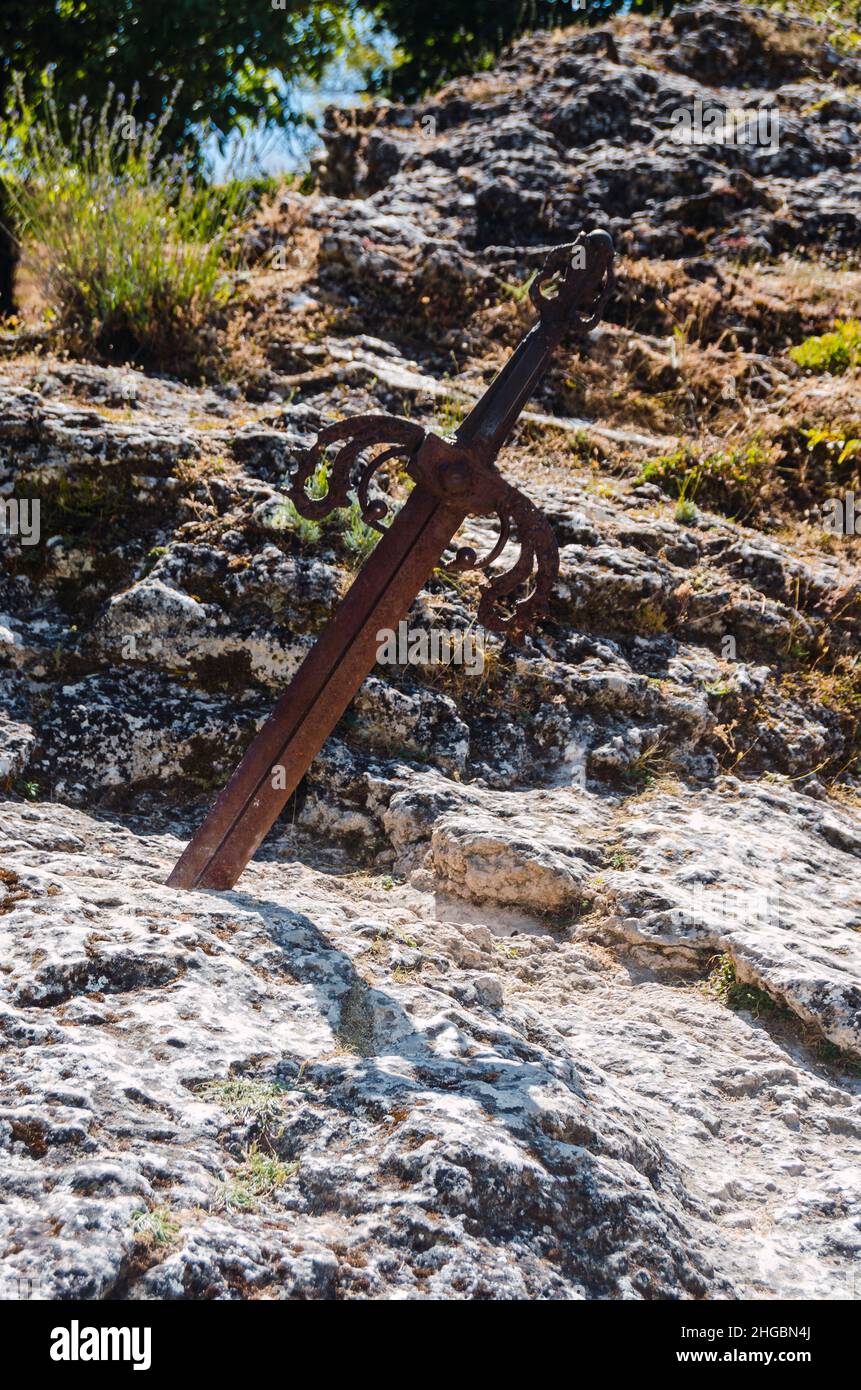 Rostiges Schwert, in einen Felsen gehauen, als wäre es das Schwert von König Arthur Excalibur im Dorf Caleruega, Burgos, Castilla y León, Spanien. Stockfoto
